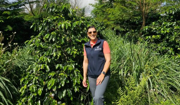 Woman standing in front of a coffee tree